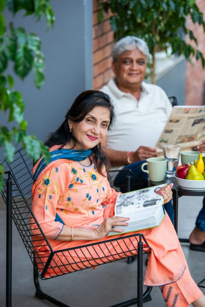 Indian asian senior couple spends quality time in morning reads newspaper while taking breakfast